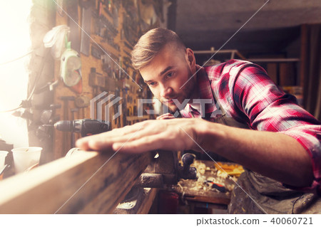 carpenter working with wood plank at workshop carpenter working with wood plank at workshop 40060721