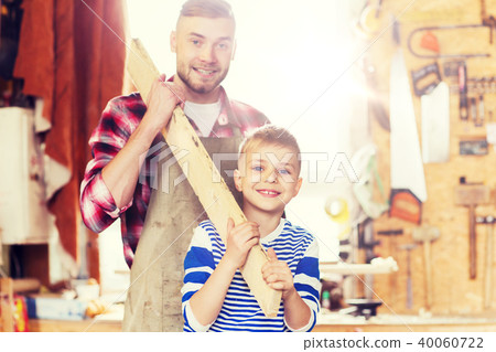 happy father and son with wood plank at workshop happy father and son with wood plank at workshop 40060722