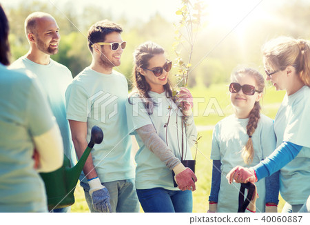 group of volunteers with trees and rake in park group of volunteers with trees and rake in park 40060887