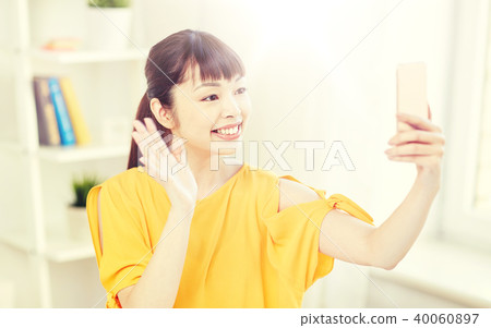 happy asian woman taking selfie with smartphone happy asian woman taking selfie with smartphone 40060897