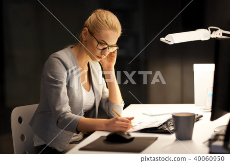 businesswoman with papers working at night office 40060950