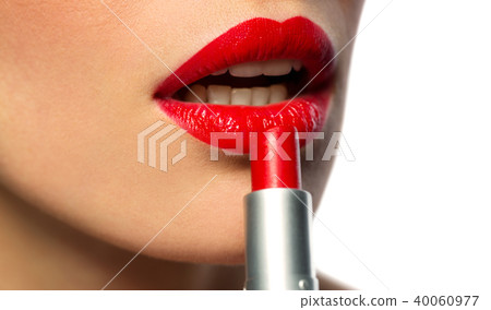 close up of woman applying red lipstick to lips 40060977