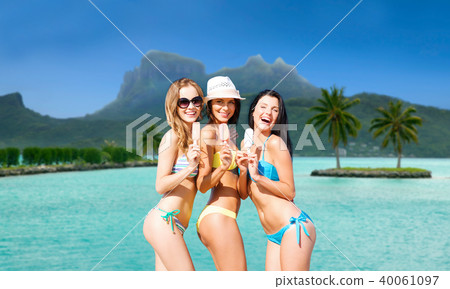 group of smiling women eating ice cream on beach group of smiling women eating ice cream on beach 40061097