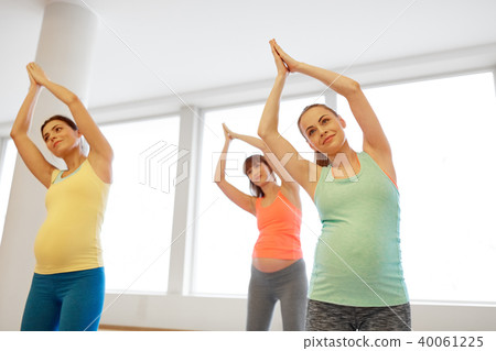 happy pregnant women exercising on mats in gym happy pregnant women exercising on mats in gym 40061225