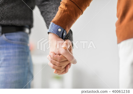 close up of male gay couple holding hands 40061238