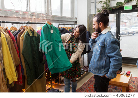 couple choosing clothes at vintage clothing store couple choosing clothes at vintage clothing store 40061277