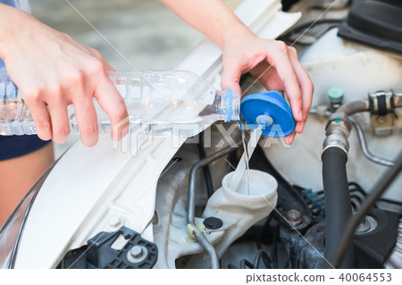 Hands of filling water into the canister of car. 40064553