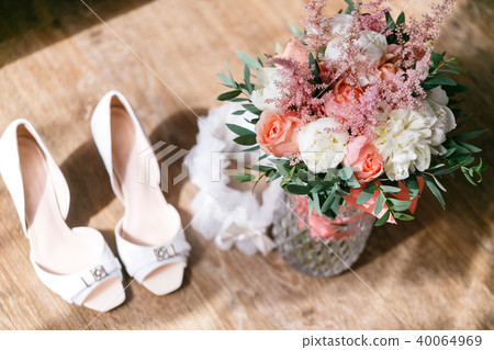 Wedding bouquet of white roses and buttercup on a wooden table. Lots of greenery, modern 40064969