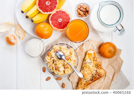 healthy breakfast. bowl of cornflakes, fruit, fresh juice, milk 40065288