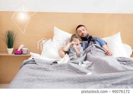 Unwell father and daughter sleeping together  40076172