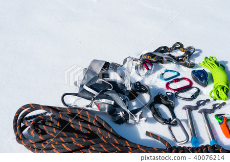 Close-up of winter climbing equipment on fresh snow on a sunny day. Carbines with a rope gazebo and 40076214