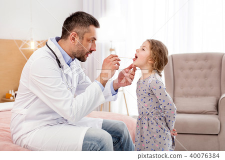 Determined doctor examining his patient Determined doctor examining his patient 40076384