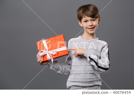 Positive cute boy pointing at the gift box Positive cute boy pointing at the gift box 40076454
