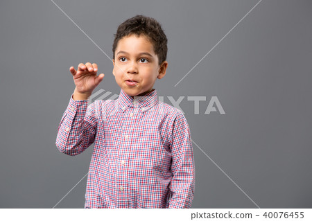 Pleasant nice boy looking at his hand Pleasant nice boy looking at his hand 40076455