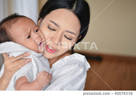 Newborn Concept. Mother and child on a white bed. Mom and baby b 40076556