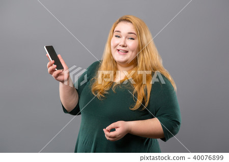 Joyful obese woman holding her phone 40076899