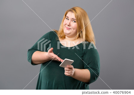 Nice emotional woman holding her smartphone Nice emotional woman holding her smartphone 40076904