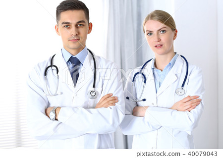 Doctors standing straight with arms crossed in hospital. Physicians ready to help. Concept of 40079043