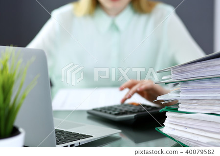 Bookkeeper or financial inspector making report, calculating or checking balance. Binders wit Bookkeeper or financial inspector making report, calculating or checking balance. Binders wit 40079582