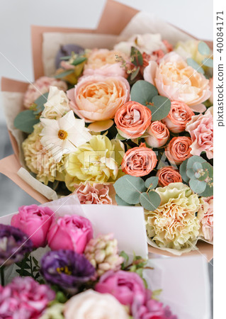 two bouquet of beautiful flowers on gray table. Floristry concept. Spring colors. the work of the two bouquet of beautiful flowers on gray table. Floristry concept. Spring colors. the work of the 40084171