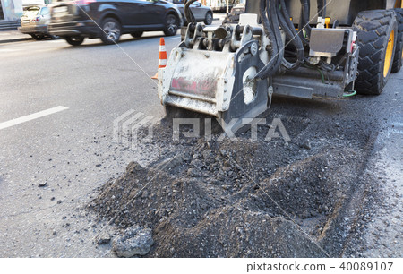 Tractor with a nozzle repairs the asphalt road. 40089107