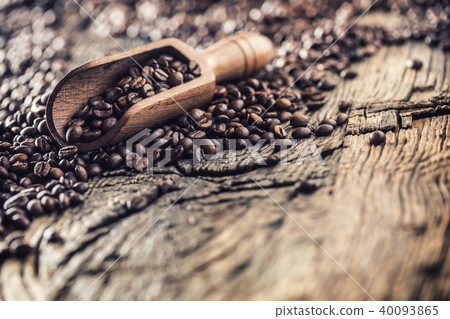 Wooden scoop full of coffee beans on old oak table 40093865