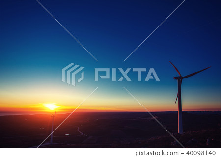 Solar wind turbines at sunset. 40098140