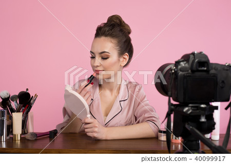 Positive female blogger is filming makeup tutorial 40099917