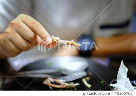 Hand holding bone of Roasted chicken leg Hand holding bone of Roasted chicken leg 40100762