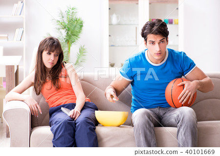 Man watching basketball with his wife Man watching basketball with his wife 40101669