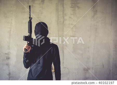 Terrorist holding rifle gun on grunge wall 40102197