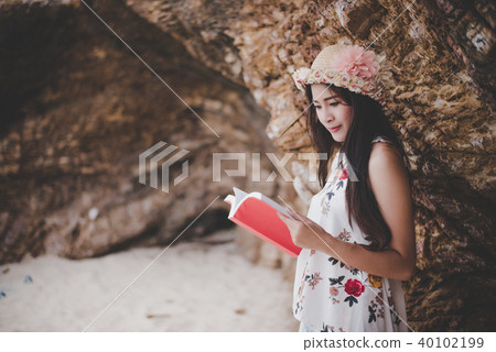 Beauty Asian woman reading book at beach Beauty Asian woman reading book at beach 40102199