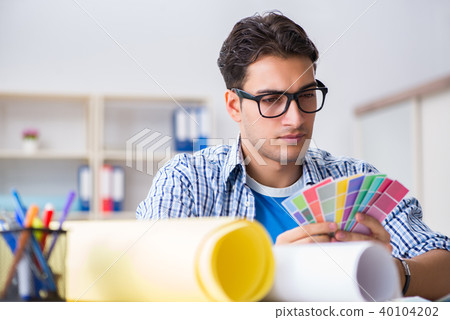 Young designer working on new project and choosing colours 40104202