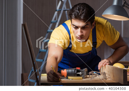 Worker working in repair workshop in woodworking concept 40104308