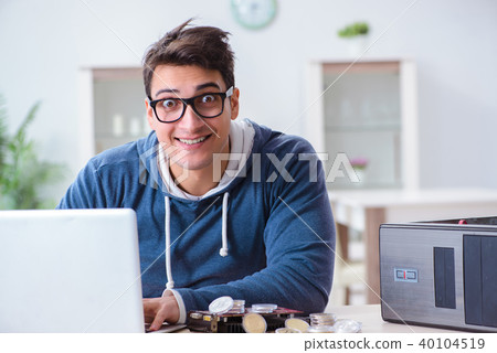 Young man mining bitcoins at home 40104519
