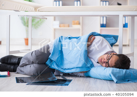 Doctor sleeping on floor after long night shift Doctor sleeping on floor after long night shift 40105094