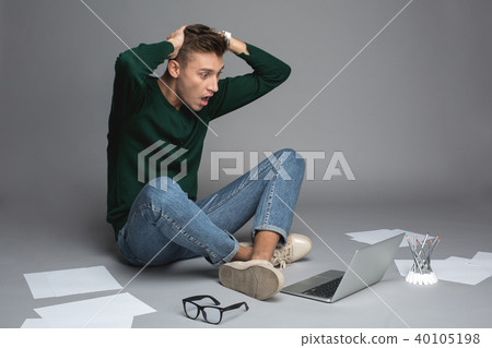 Young man with notebook being shocked Young man with notebook being shocked 40105198