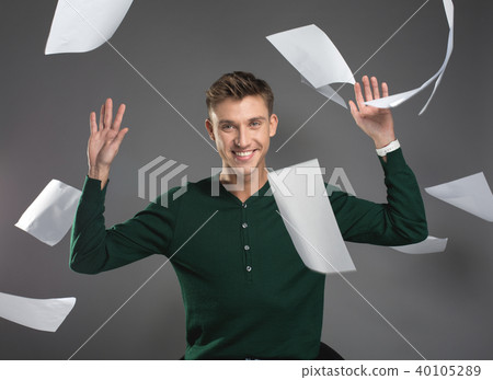 Young man throwing up papers with happy face 40105289