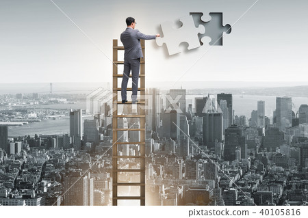 Businessman putting together jigsaw puzzle pieces Businessman putting together jigsaw puzzle pieces 40105816