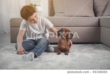 Happy kid playing with puppy in house Happy kid playing with puppy in house 40106084