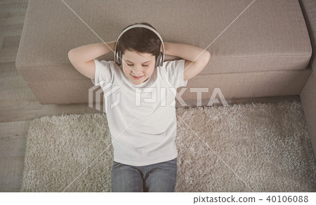 Happy child relaxing with earphones at home Happy child relaxing with earphones at home 40106088