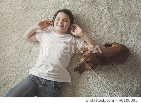 Glad child and puppy relaxing on floor Glad child and puppy relaxing on floor 40106095