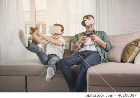 Cheerful parent and child having fun with gadgets Cheerful parent and child having fun with gadgets 40106097