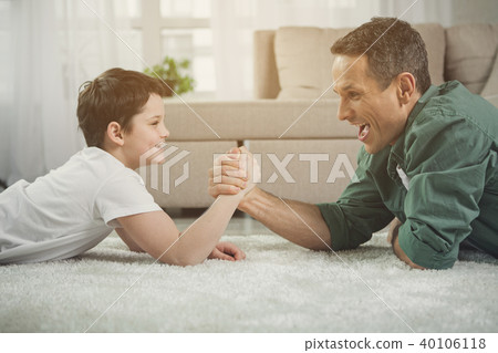 Joyful man and boy are measuring their strength in arms Joyful man and boy are measuring their strength in arms 40106118