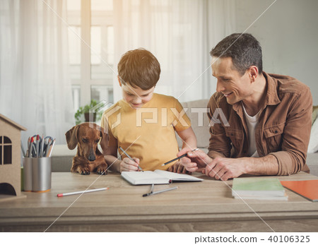 Happy father and son doing art near dog 40106325