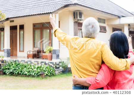 Elderly man pointing to his wife a comfortable residential house 40112308