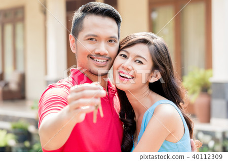 Portrait of young happy couple posing with the keys of a new house Portrait of young happy couple posing with the keys of a new house 40112309