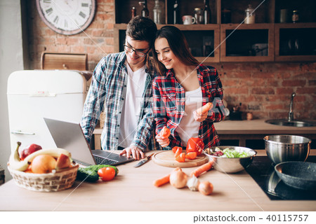 Couple looks at a recipe in laptop, salad cooking Couple looks at a recipe in laptop, salad cooking 40115757