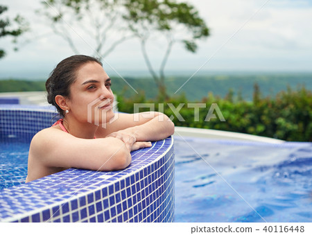 Young woman relaxing in pool Young woman relaxing in pool 40116448