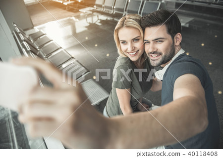 Cheerful couple taking photo by phone Cheerful couple taking photo by phone 40118408